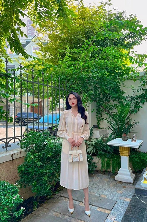 Tông trắng kem tạo cảm giác dịu mắt được Hương Giang phối đồng điệu giữa sơ mi cùng chân váy midi. Người đẹp dùng bộ phụ kiện túi hiệu Goya quai gỗ để tạo điểm nhấn cho tổng thể.