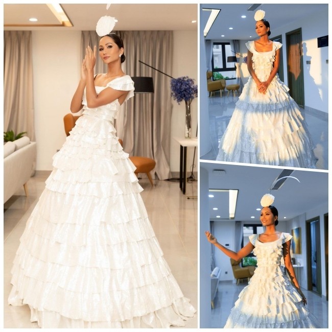 Hoá thân thành nàng công chúa trong chiếc váy trắng thướt tha, yêu kiều, nàng hậu đẹp dịu dàng, kiêu kỳ, thu hút mọi ánh nhìn. Chiếc váy công chúa thiết kế cổ vuông kết hợp nhiều lớp bồng bềnh được cắt may tinh tế giúp H'Hen Niê tôn được vóc dáng mảnh mai. Tóc búi gọn cùng phụ kiện đội đầu độc đáo là điểm cộng khiến cô thêm phần quý phái.