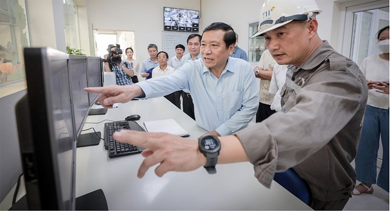 Đoàn đại biểu nghe giới thiệu về quy trình chăn nuôi bò sữa công nghệ cao.