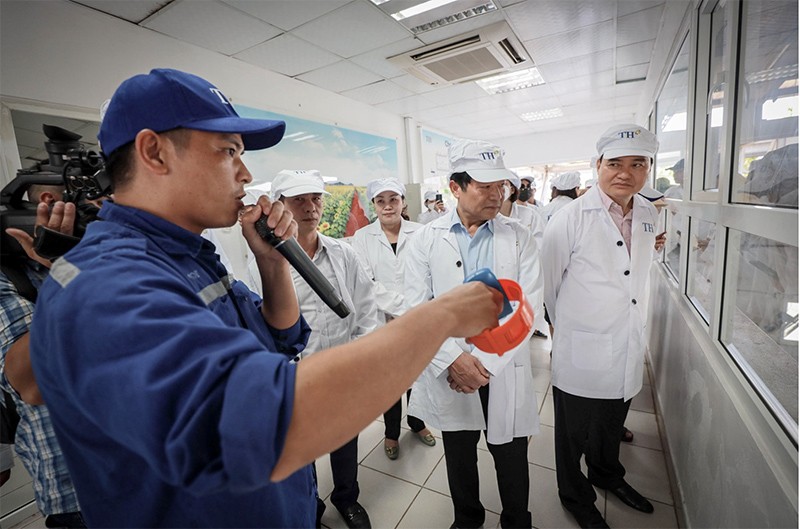 Đoàn đại biểu nghe giới thiệu về quy trình chăn nuôi bò sữa công nghệ cao.