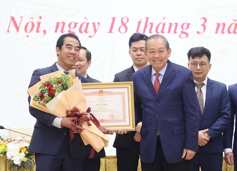 Thứ trưởng Tô Anh Dũng tiếp nhận Bằng khen của Thủ tướng Chính phủ từ Phó Thủ tướng thường trực Trương Hòa Bình. (Nguồn: VGP)