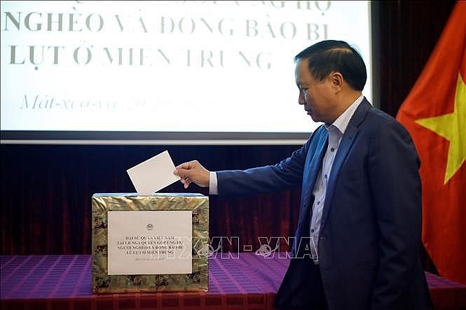 Đại sứ Ngô Đức Mạnh quyên góp ủng hộ đồng bào bị thiệt hại do lũ lụt tại các tỉnh miền Trung. (Nguồn: TTXVN) Lũ lụt miền Trung: Người Việt tại Nga một lòng hướng về miền Trung