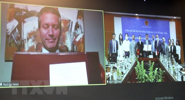 Thứ trưởng Bộ Công Thương Đỗ Thắng Hải tại đầu cầu Hà Nội và Thứ trưởng phụ trách Thương mại, Bộ Ngoại giao Chile Rodrigo Yanez tại đầu cầu Santiago de Chile ký kết Biên bản ghi nhớ phiên họp. (Ảnh: Trần Việt/TTXVN)