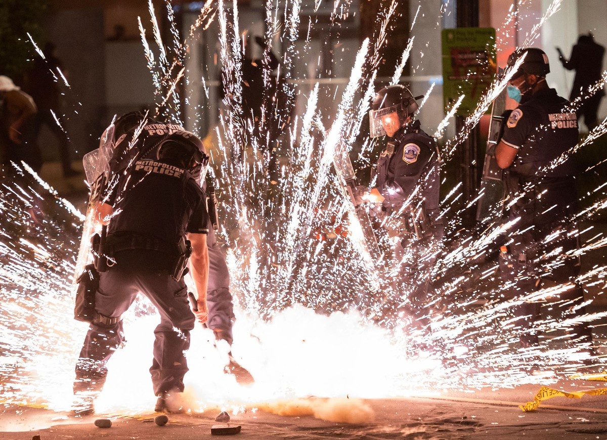 Người biểu tình ném pháo hoa vào lực lượng cảnh sát ngay gần Nhà Trắng ở thủ đô Washington D.C., trong cuộc biểu tình phản đối vụ người đàn ông gốc Phi George Floyd bị cảnh sát ghì cổ đến tử vong do nghi ngờ sử dụng tiền giả hôm 25/5 tại thành phố Minneapolis, Minnesota, Mỹ. (Nguồn: Getty Images) 3153-1