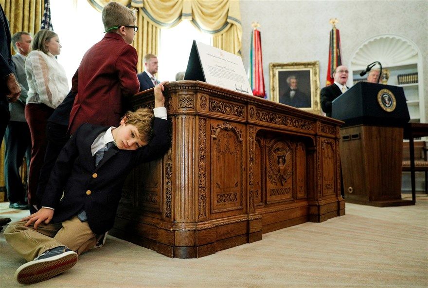 Cậu bé Sammy Olszta, 6 tuổi, cháu trai của đô vật Olympic Dan Gable, dựa vào bàn của Phòng Bầu dục trong buổi lễ trao Huân chương Tự do của Tổng thống cho Gable, ngày 7/12, tại Nhà Trắng, Washington, Mỹ. (Nguồn: Reuters)