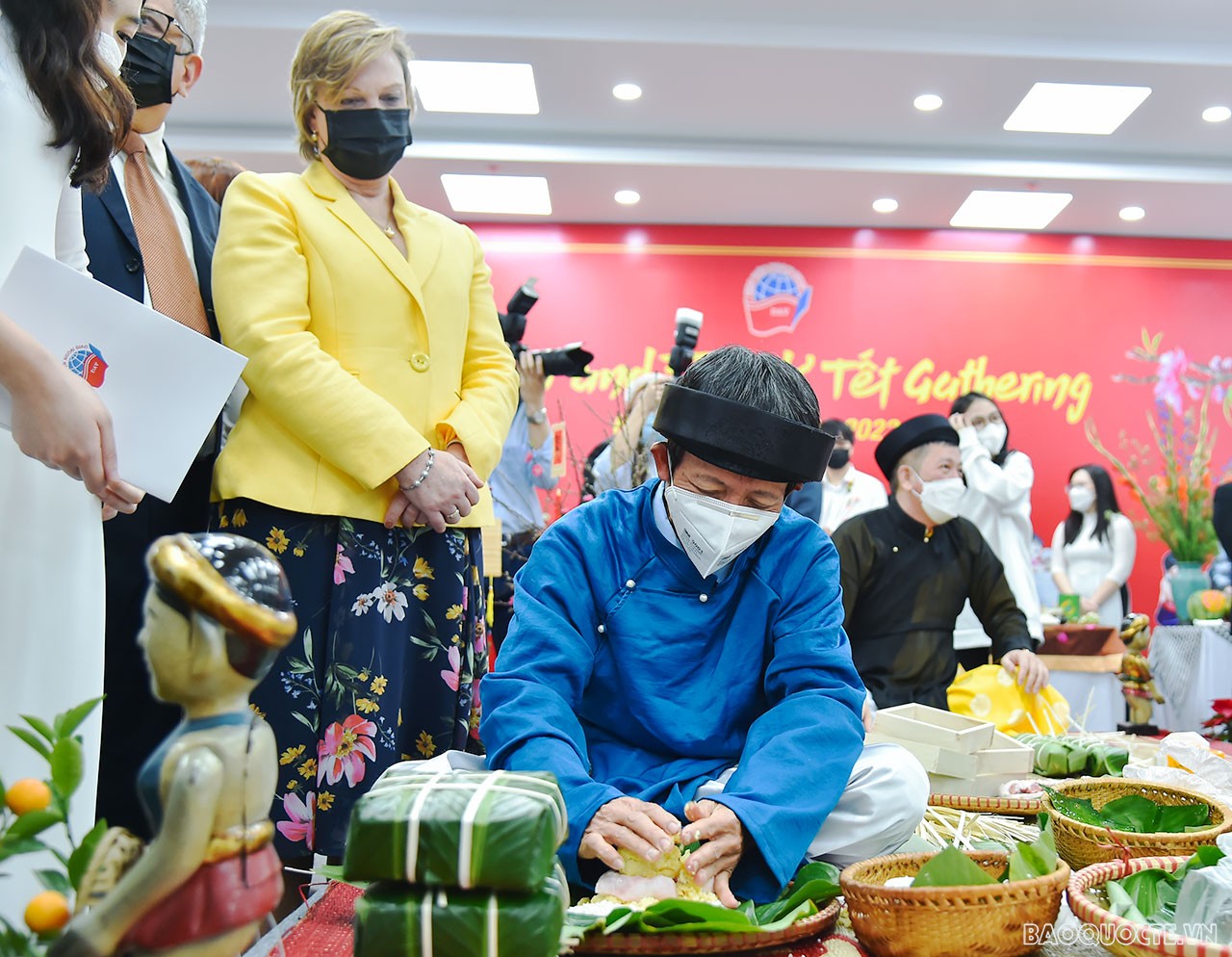 Bạn bè quốc tế theo dõi các nghệ nhân gói bánh trưng.