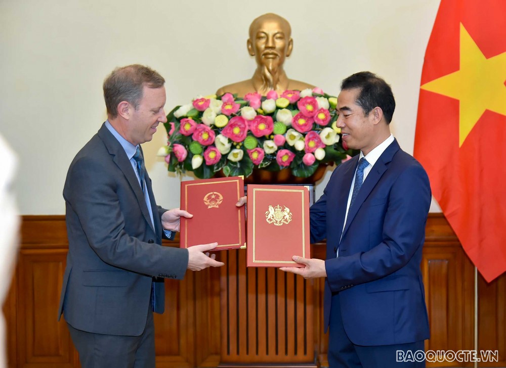 Thứ trưởng Ngoại giao Tô Anh Dũng và Đại sứ Anh tại Việt Nam Gareth Ward trao đổi Công hàm khẳng định ngày có hiệu lực của UKVFTA. (Ảnh: Tuấn Anh)