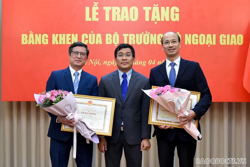 Thứ trưởng Ngoại giao Nguyễn Minh Vũ trao Bằng khen của Bộ trưởng Ngoại giao cho ông Bùi Lê Thái, Chánh Văn phòng Ban Đối ngoại Trung ương (phải) và ông Nguyễn Hồng Quang, Phó Vụ trưởng Vụ Quan hệ quốc tế, Văn phòng Chính phủ.