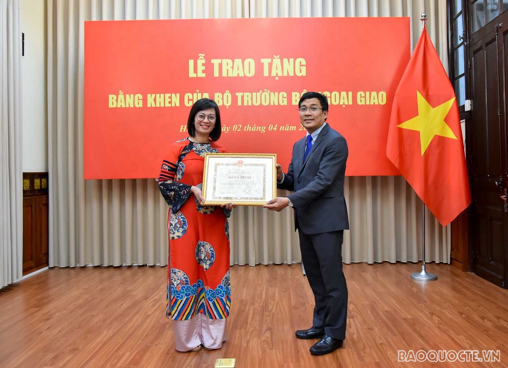Thứ trưởng Ngoại giao Nguyễn Minh Vũ trao Bằng khen của Bộ trưởng Ngoại giao cho bà Nguyễn Thùy Linh, Trưởng phòng tổng hợp, Trung tâm Đào tạo, Bồi dưỡng cán bộ đối ngoại (FOSET), Học viện Ngoại giao.