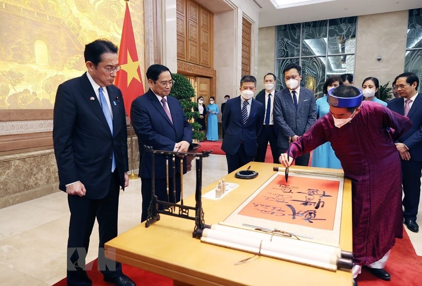 Thủ tướng Phạm Minh Chính và Thủ tướng Nhật Bản Kishida Fumio xem viết thư pháp. (Nguồn: TTXVN)