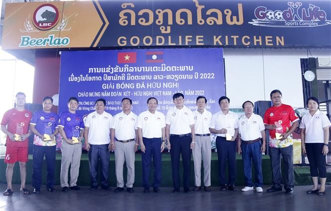 Đại sứ Việt Nam tại Lào và Bộ trưởng Giáo dục và Thể thao Lào đang chụp ảnh lưu niệm với các đội tham gia giải đấu. (Nguồn: TTXVN) Đại sứ Việt Nam tại Lào và Bộ trưởng Giáo dục và Thể thao Lào đang chụp ảnh lưu niệm với các đội tham gia giải đấu. (Nguồn: TTXVN)