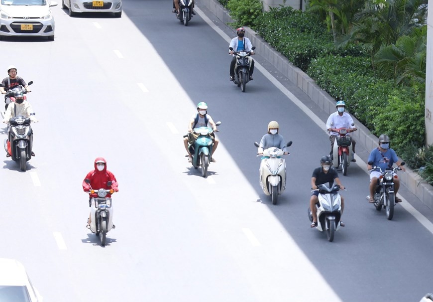 Để tránh nắng nóng, nhiều xe máy di chuyển sang bên làn đường ô tô.