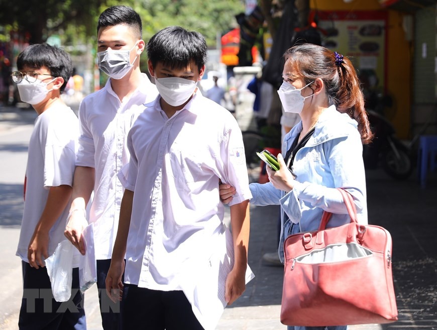 Phụ huynh đón con em dưới thời tiết nắng nóng.