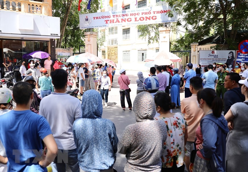 Dù nắng nóng nhưng vẫn rất đông người dân đứng đón con trước cổng